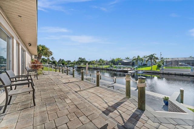 view of patio featuring a water view, a lanai, and a boat dock