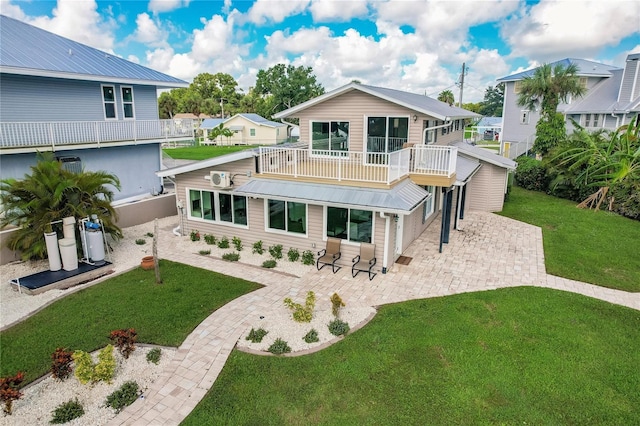 back of property with a lawn and a patio area