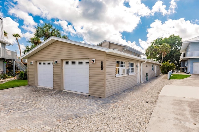 exterior space with a garage and decorative driveway