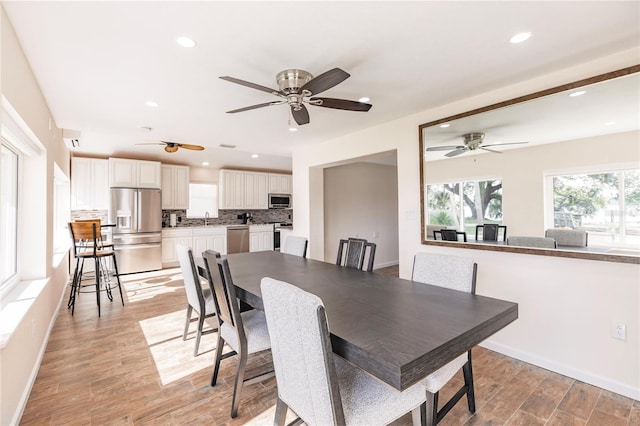 dining room with light hardwood / wood-style flooring, sink, and ceiling fan