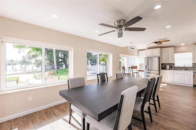 dining area with light wood-type flooring, sink, and ceiling fan