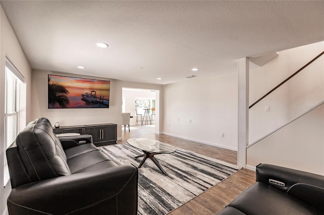 living room with recessed lighting, visible vents, a textured ceiling, wood finished floors, and baseboards