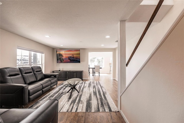 living room featuring a textured ceiling and dark wood-type flooring