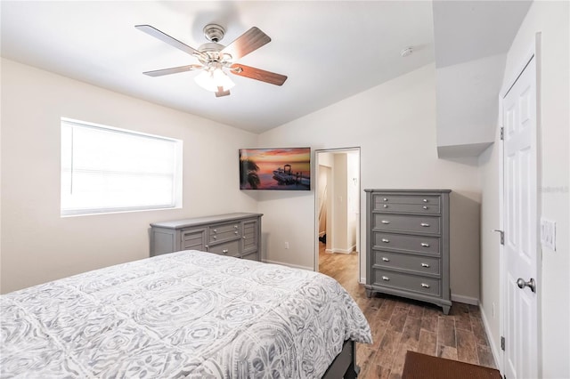 bedroom featuring lofted ceiling, a ceiling fan, baseboards, and dark wood-style flooring