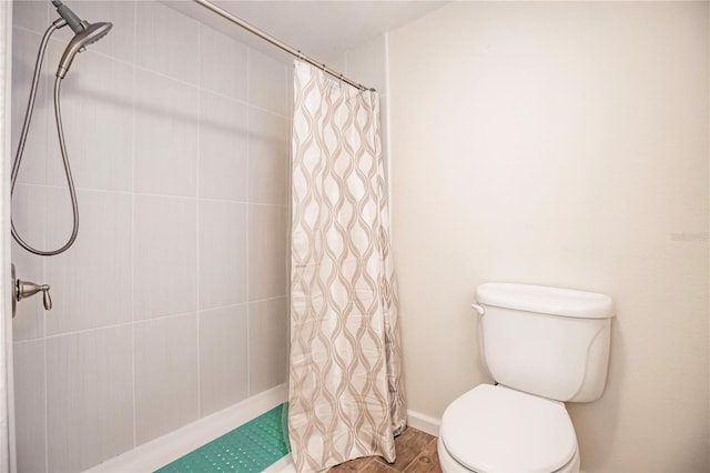 bathroom featuring a shower with shower curtain, toilet, and hardwood / wood-style flooring