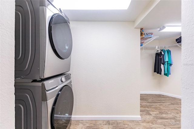 laundry area with stacked washing maching and dryer and light wood-type flooring