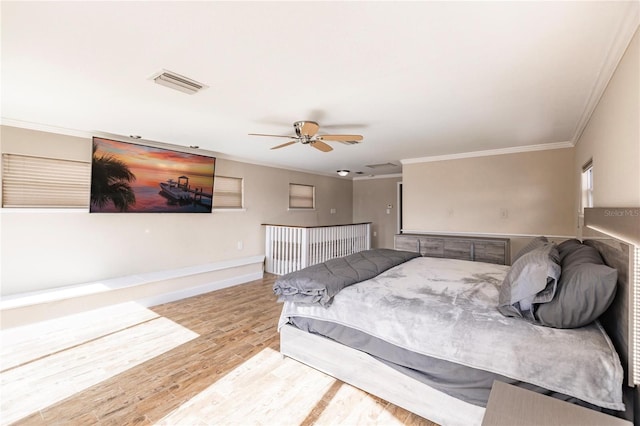 bedroom with ceiling fan, ornamental molding, and light hardwood / wood-style flooring