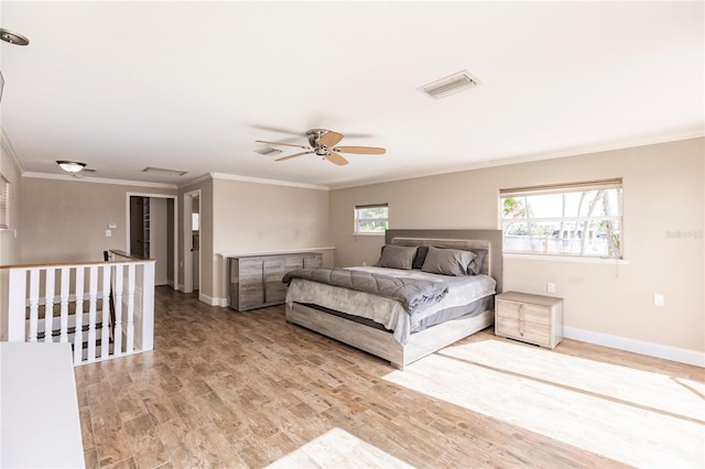 bedroom featuring baseboards, visible vents, ceiling fan, wood finished floors, and crown molding