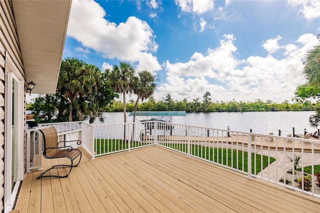 wooden deck with a water view and a lawn