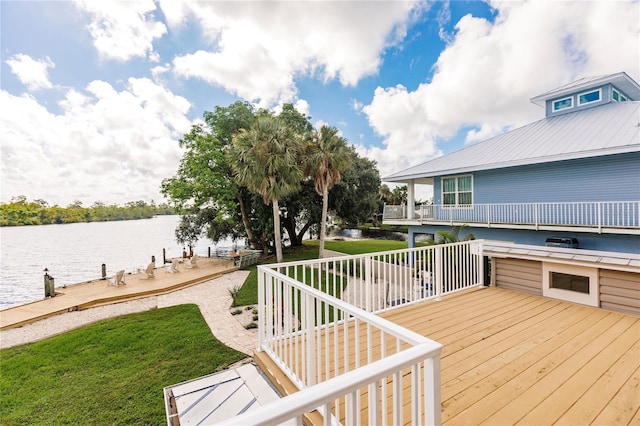 wooden deck with a yard, a water view, and area for grilling