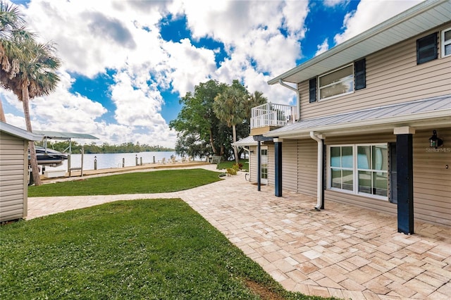 view of yard featuring a water view and a patio