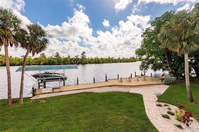 view of dock with a yard and a water view