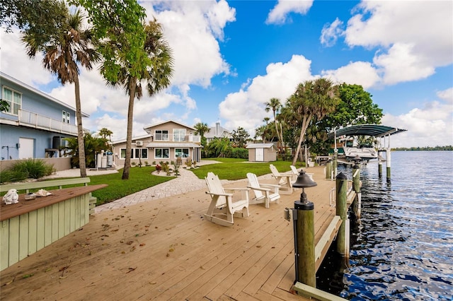 view of dock with a lawn and a water view