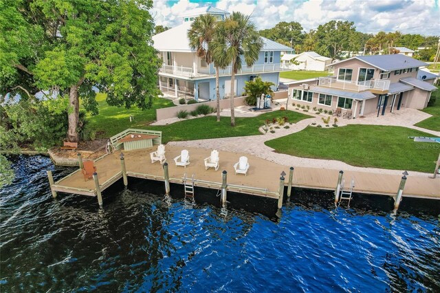 dock area with a patio area, a balcony, a lawn, a swimming pool, and a water view