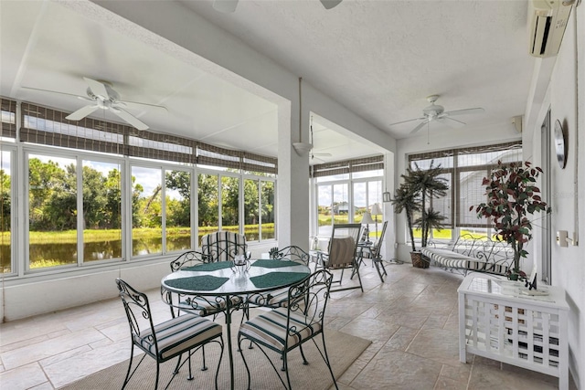 sunroom / solarium featuring ceiling fan, an AC wall unit, and a water view