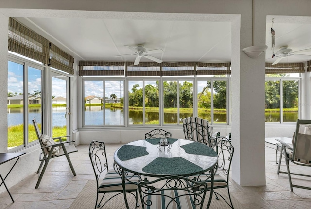 sunroom / solarium featuring a water view and ceiling fan