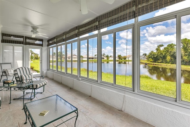sunroom / solarium featuring ceiling fan and a water view