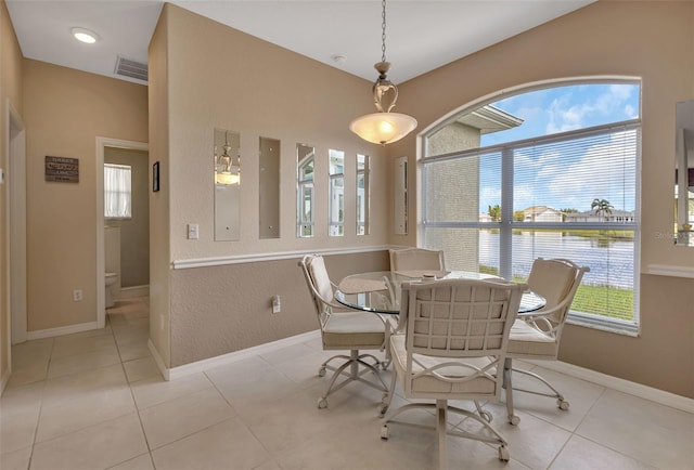 dining room featuring a water view and light tile patterned flooring