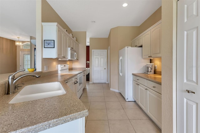 kitchen featuring a sink, light tile patterned flooring, a chandelier, white cabinetry, and white appliances