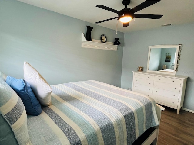 bedroom with ceiling fan, wood finished floors, and visible vents