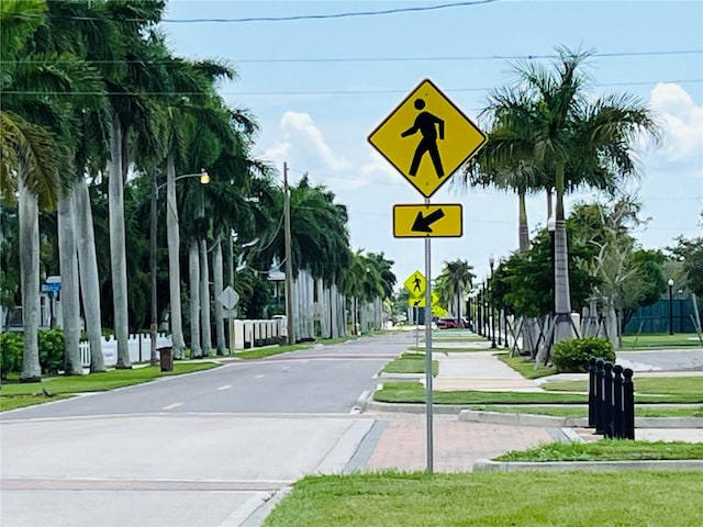 view of street featuring curbs, street lighting, traffic signs, and sidewalks