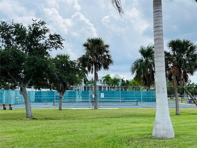 view of property's community featuring tennis court and a lawn