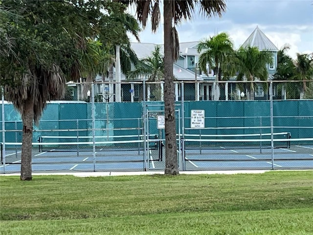 view of sport court with a yard and fence