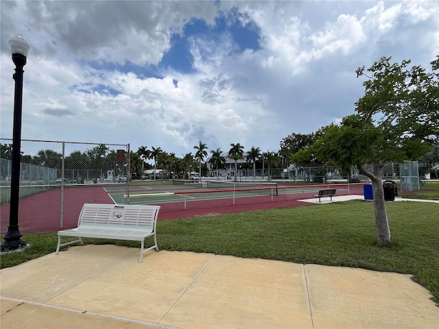 view of tennis court featuring a lawn