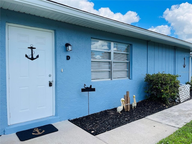 view of exterior entry featuring stucco siding