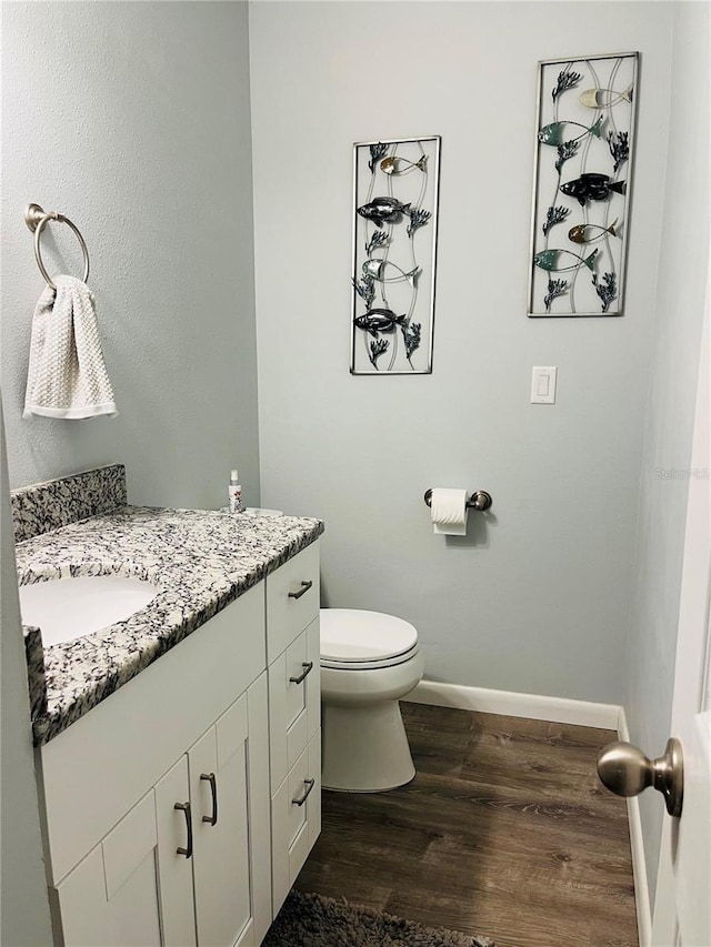 bathroom featuring vanity, toilet, and hardwood / wood-style flooring