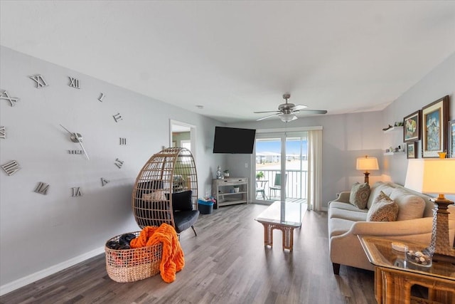 living room featuring dark wood-type flooring and ceiling fan