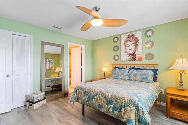 bedroom with wood-type flooring, ceiling fan, and a closet