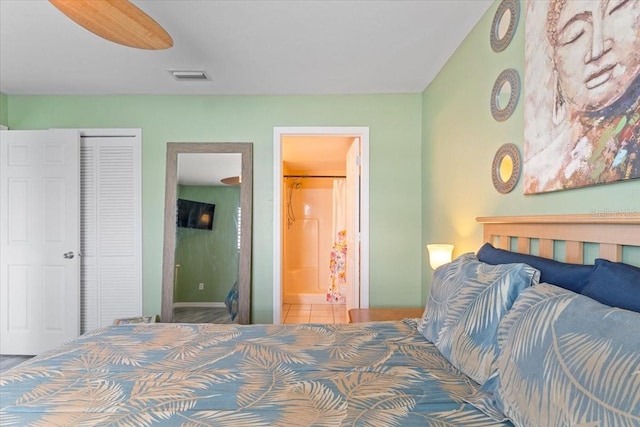 tiled bedroom featuring ceiling fan, a closet, and ensuite bathroom