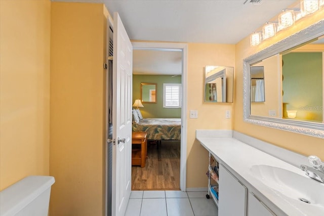 bathroom featuring vanity, toilet, and tile patterned flooring