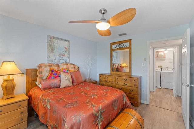 bedroom featuring light wood-type flooring, washing machine and dryer, visible vents, and a ceiling fan