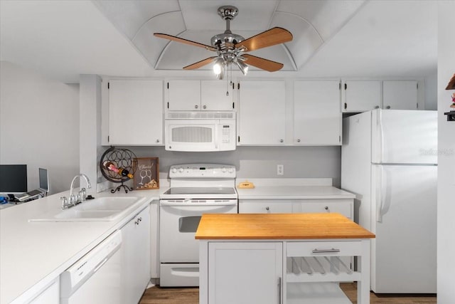 kitchen with white appliances, sink, hardwood / wood-style flooring, ceiling fan, and white cabinets