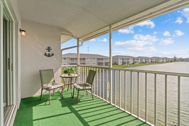 balcony featuring a residential view and a water view