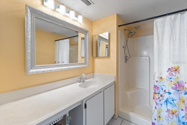 bathroom featuring curtained shower, tile patterned flooring, and vanity