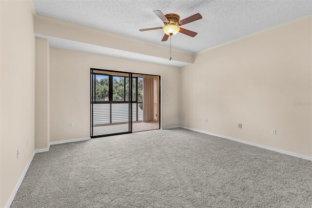 carpeted spare room featuring crown molding, ceiling fan, a textured ceiling, and baseboards