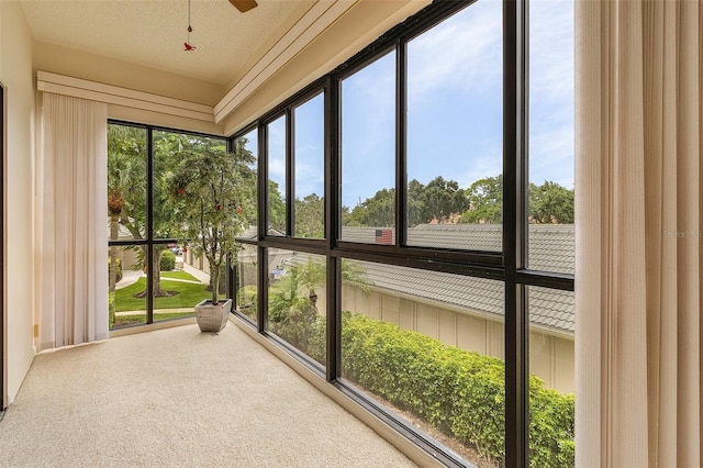 unfurnished sunroom with a ceiling fan