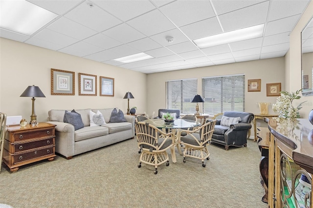 living area with carpet floors and a drop ceiling