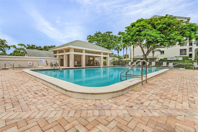 community pool with fence and a patio