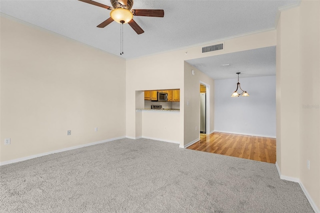 unfurnished living room with light carpet, baseboards, visible vents, ceiling fan, and a textured ceiling