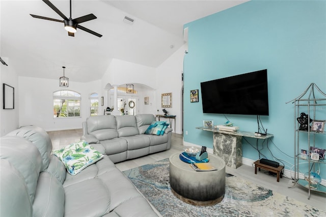 living area featuring arched walkways, ceiling fan, high vaulted ceiling, visible vents, and baseboards