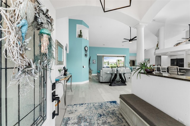 living room featuring ceiling fan, light hardwood / wood-style floors, and decorative columns