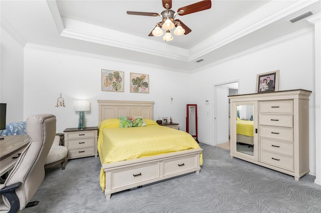 bedroom featuring carpet, ceiling fan, ornamental molding, and a tray ceiling