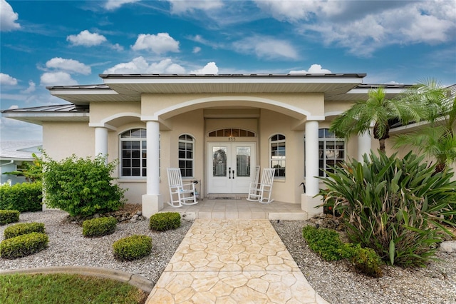 doorway to property with covered porch and french doors