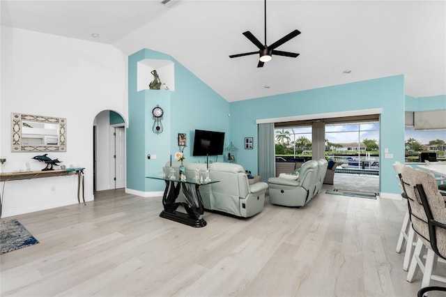 living room featuring light hardwood / wood-style floors, high vaulted ceiling, and ceiling fan