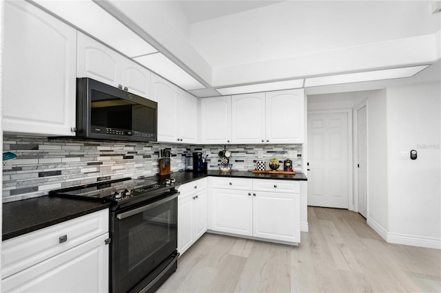 kitchen with decorative backsplash, light hardwood / wood-style floors, white cabinetry, and black appliances