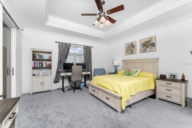 carpeted bedroom featuring ceiling fan, a raised ceiling, and ornamental molding